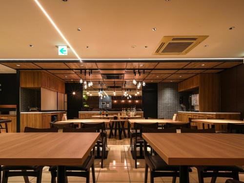 a restaurant with wooden tables and chairs and lights at Super Hotel Hiroshima in Hiroshima