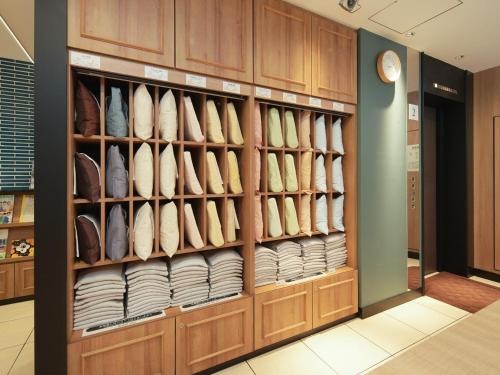a room with wooden cabinets and shelves with shoes at Super Hotel Hiroshima in Hiroshima