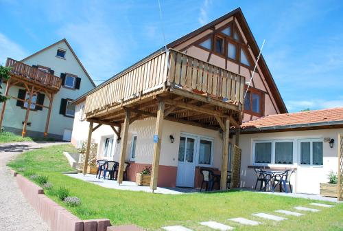 a house with a deck on the side of it at Chambres d'hôtes Les vignes in Saint-Jean-Saverne