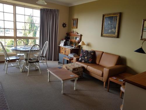 una sala de estar con un sofá y una mesa en Cornwall Cottage, en Cambridge