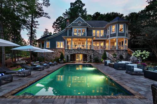 a house with a swimming pool in front of a house at The Ritz-Carlton Reynolds, Lake Oconee in Turnwold