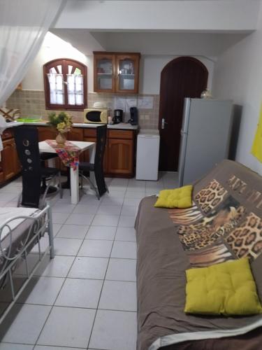 sala de estar con 2 camas y cocina en Studio à louer dans un Villa, en Le Moule