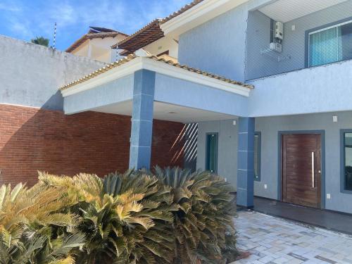 una casa con columnas azules y plantas delante de ella en Duplex com piscina no Grangeiro, en Crato