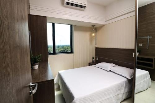 a bedroom with a white bed and a window at Tropical Executive 1006 in Manaus