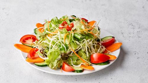 a salad on a white plate on a table at Hotel Meriken Port Kobe Motomachi in Kobe
