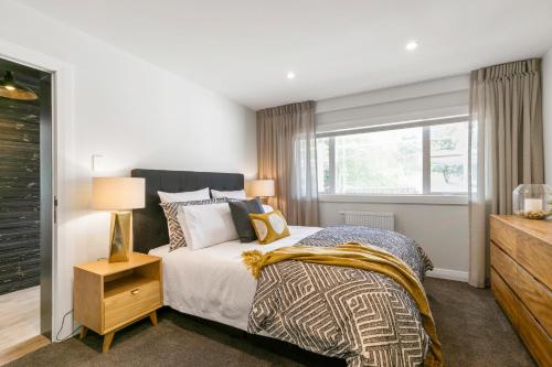 Schlafzimmer mit einem Bett und einem Fenster in der Unterkunft The Village Reserve Boutique Accomodation in Auckland