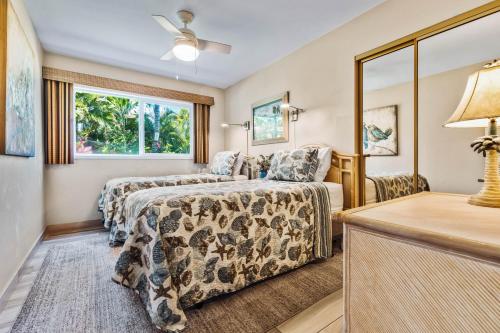 um quarto de hotel com duas camas e uma janela em Noelani 101 em Kahana