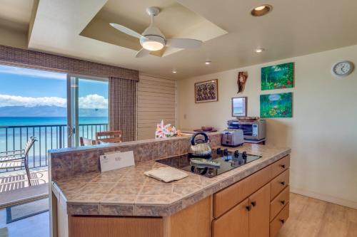 a kitchen with a counter top with a view of the ocean at Maui Sands #5G in Kahana