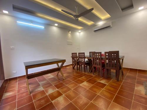a dining room with a table and chairs and a ceiling at Athirappilly Heritage Villa in Athirappilly