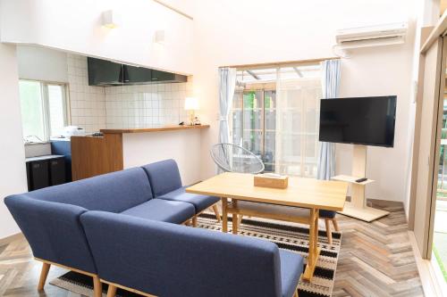 a living room with a blue couch and a table at S-villa Nasu 11th in Nasu
