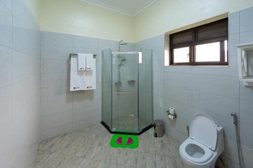 a bathroom with a glass shower and a toilet at Las Vegas Garden Hotel Mbarara in Mbarara