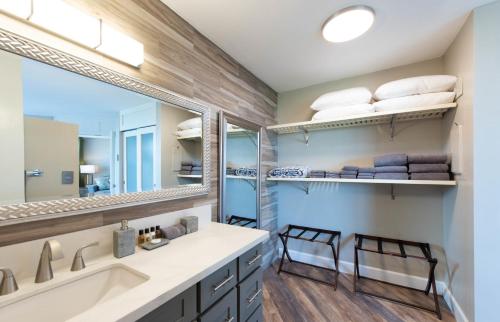 een badkamer met een wastafel en een spiegel bij Refined Oceanfront Retreat in Kihei