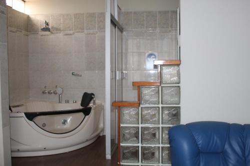 a bath tub in a bathroom with a shower at Hotel Caribe Azul in Chancay