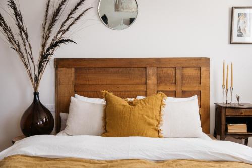 a bedroom with a bed with white sheets and yellow pillows at Ocean beach front, 3 Capes Cottage. in Eaglehawk Neck
