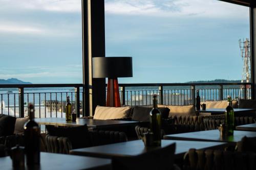 a restaurant with tables and chairs with a view of the ocean at Hotel XYZ in Tacloban