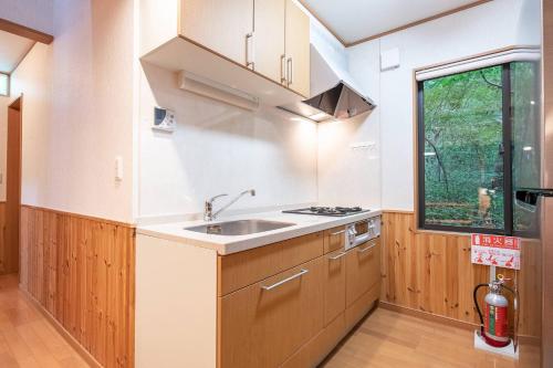 a kitchen with wooden cabinets and a sink and a window at S-villa Nasu 7th in Nasu