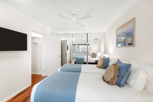 a bedroom with two beds and a flat screen tv at Belle Escapes Suite 27 Alamanda Palm Cove in Palm Cove