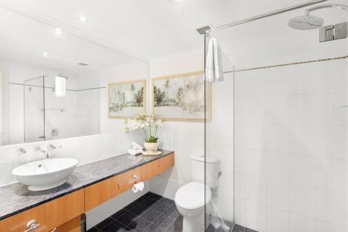 a white bathroom with a sink and a toilet at Belle Escapes Suite 27 Alamanda Palm Cove in Palm Cove