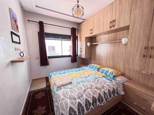 アウリールにあるAourir Beachfront Surf Apartmentのベッドと窓のある寝室