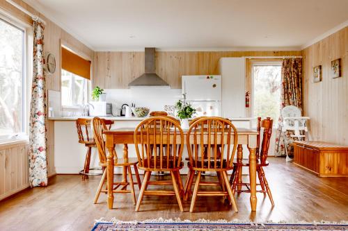 uma cozinha com uma mesa de madeira e cadeiras em Freshwater Creek Cottages & Farm Stay em Torquay