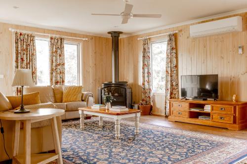 sala de estar con sofá y TV en Freshwater Creek Cottages & Farm Stay, en Torquay