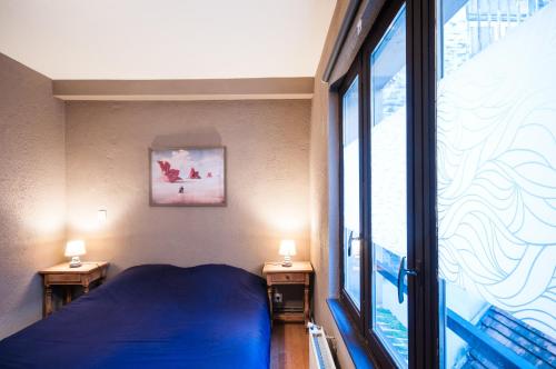 1 dormitorio con cama azul y ventana grande en Zen Appart Vieux Lille 2, en Lille