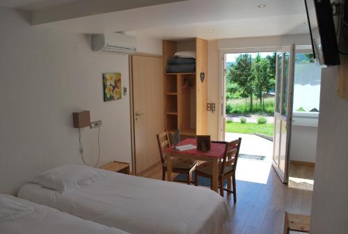 聖讓薩韋訥的住宿－萊斯維涅住宿加早餐旅館，卧室配有两张床、一张桌子和一张桌子以及椅子。