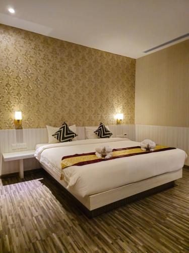 a bedroom with a large white bed in a room at Grand Sydney Hotel in Batam Center