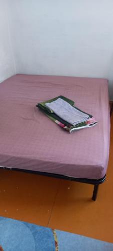 een paars bed met een boek erop bij Аренда квартир Балхаш in Balqash