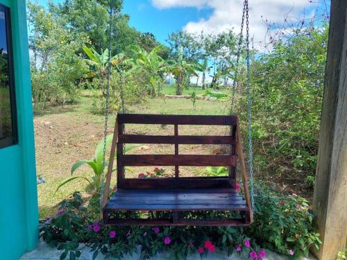 un banc à bascule dans un jardin fleuri dans l'établissement Casita Los Guarumos (Finca Las Colinas), à Bijagua