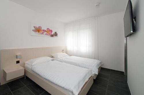 Dormitorio pequeño con cama y TV en Hotel Morobbia, en Camorino