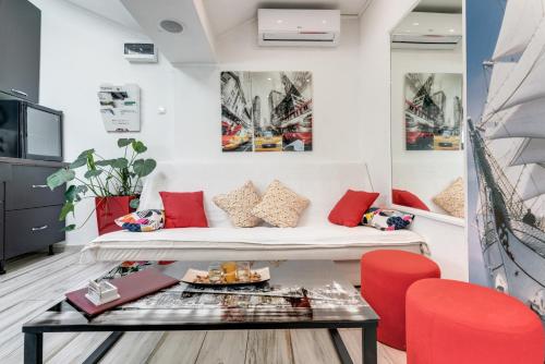 a living room with a white couch and red chairs at B&B Apartment's Coli Bakar in Bakar