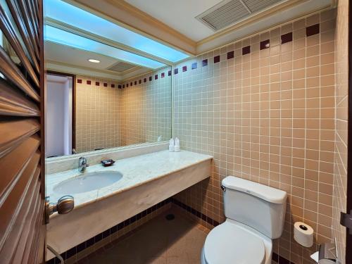 a bathroom with a toilet and a sink and a mirror at Ramada by Wyndham D MA Bangkok in Bangkok