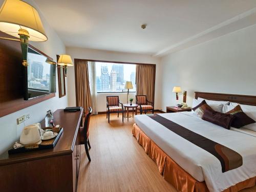 a hotel room with a large bed and a table at Ramada by Wyndham D MA Bangkok in Bangkok