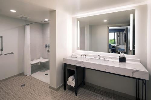 南波特蘭的住宿－Portland Sheraton at Sable Oaks，一间带水槽和大镜子的浴室
