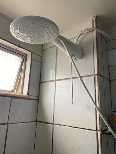 a shower head in a bathroom with a window at Apto refúgio 101 em São Luís/MA (inteiro) in São Luís