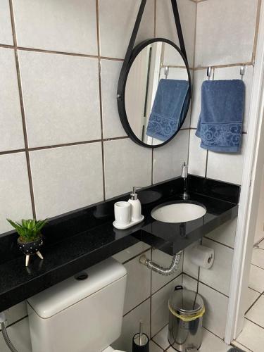 a bathroom with a sink and a mirror and a toilet at Apto refúgio 101 em São Luís/MA (inteiro) in São Luís