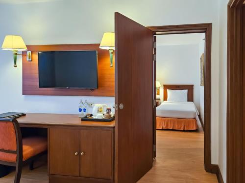 a hotel room with a desk and a bed at Ramada by Wyndham D MA Bangkok in Bangkok