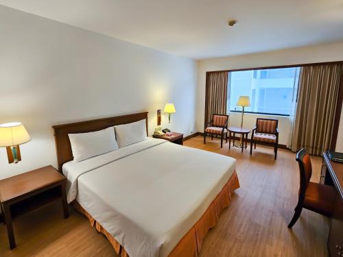 a hotel room with a large bed and a table and chairs at Ramada by Wyndham D MA Bangkok in Bangkok