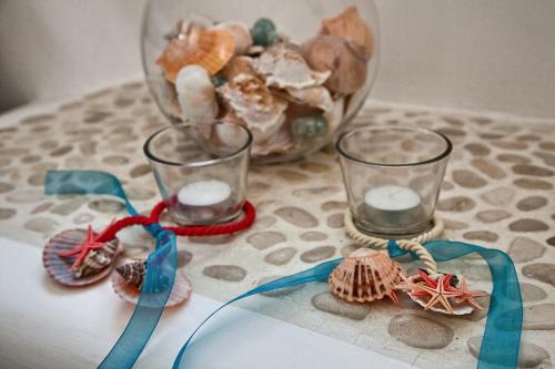 a table with two glasses and a bowl of shells at Villa Stamatina in Kyra Panagia
