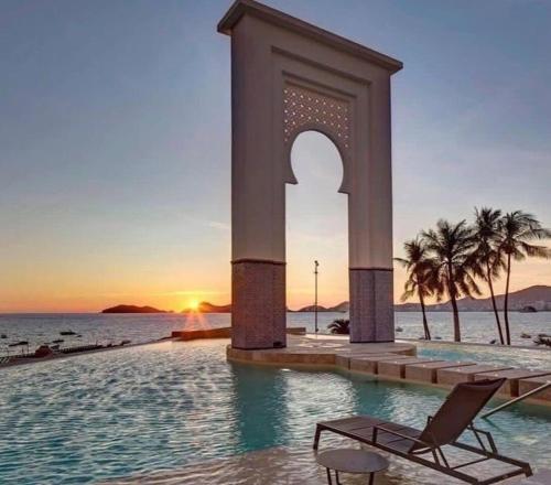 a chair sitting in a pool next to the ocean at LECLUB ACAPULCO in Acapulco