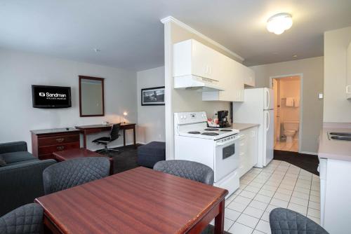 a kitchen and living room with a table and a dining room at Sandman Hotel & Suites Williams Lake in Williams Lake