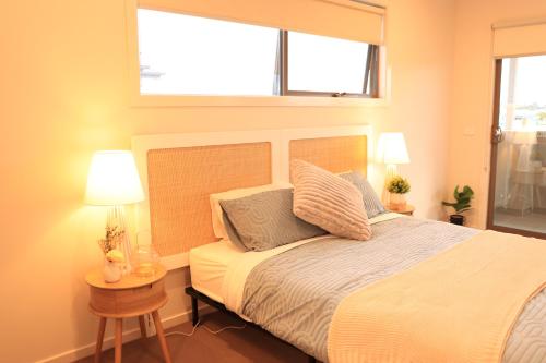 a bedroom with a bed with two lamps and a window at Melbourne holiday house for 15 peoples in Sanctuary Lake in Point Cook