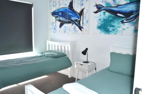 una camera con due letti e quadri di delfini di The Baltimore House - Family Getaway a Port Lincoln