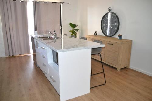 a white kitchen with a sink and a counter at The Baltimore House - Family Getaway in Port Lincoln