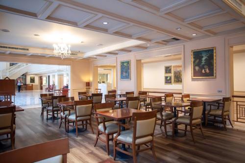 a dining room with tables and chairs and a chandelier at Ramada by Wyndham D MA Bangkok in Bangkok