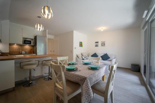 Un comedor y una cocina con mesa y sillas. en Au bonheur du lac charmant appartement pour 4 personnes, en Duingt