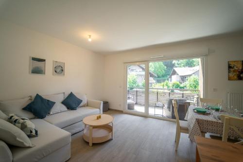 un salon avec un canapé et une table dans l'établissement Au bonheur du lac charmant appartement pour 4 personnes, à Duingt