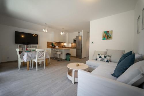 una sala de estar con un sofá y una mesa en Au bonheur du lac charmant appartement pour 4 personnes, en Duingt