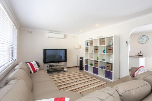 a living room with a couch and a flat screen tv at Torquay Retreats Aus- TwentyTwo Pride in Torquay